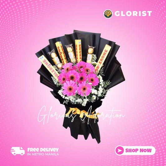 Stunning floral arrangement featuring 10 dark pink gerberas, 4 Toblerone, and 3 Ferrero Rocher chocolates with statice and misty blue fillers in black Korean wrap with gold satin ribbon - elegant flower arrangement for weddings and special occasions - flower delivery to Sta. Lucia East Grand Mall and SM City Baliwag